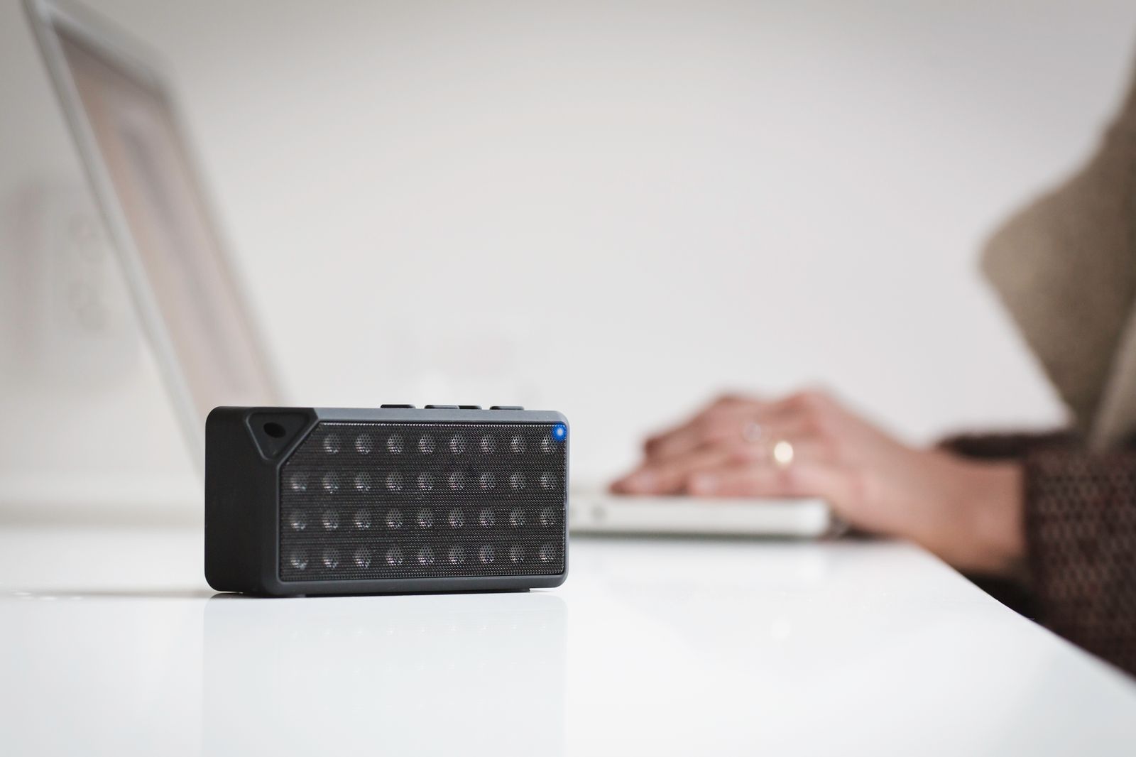 Portable wireless speaker on a white desk