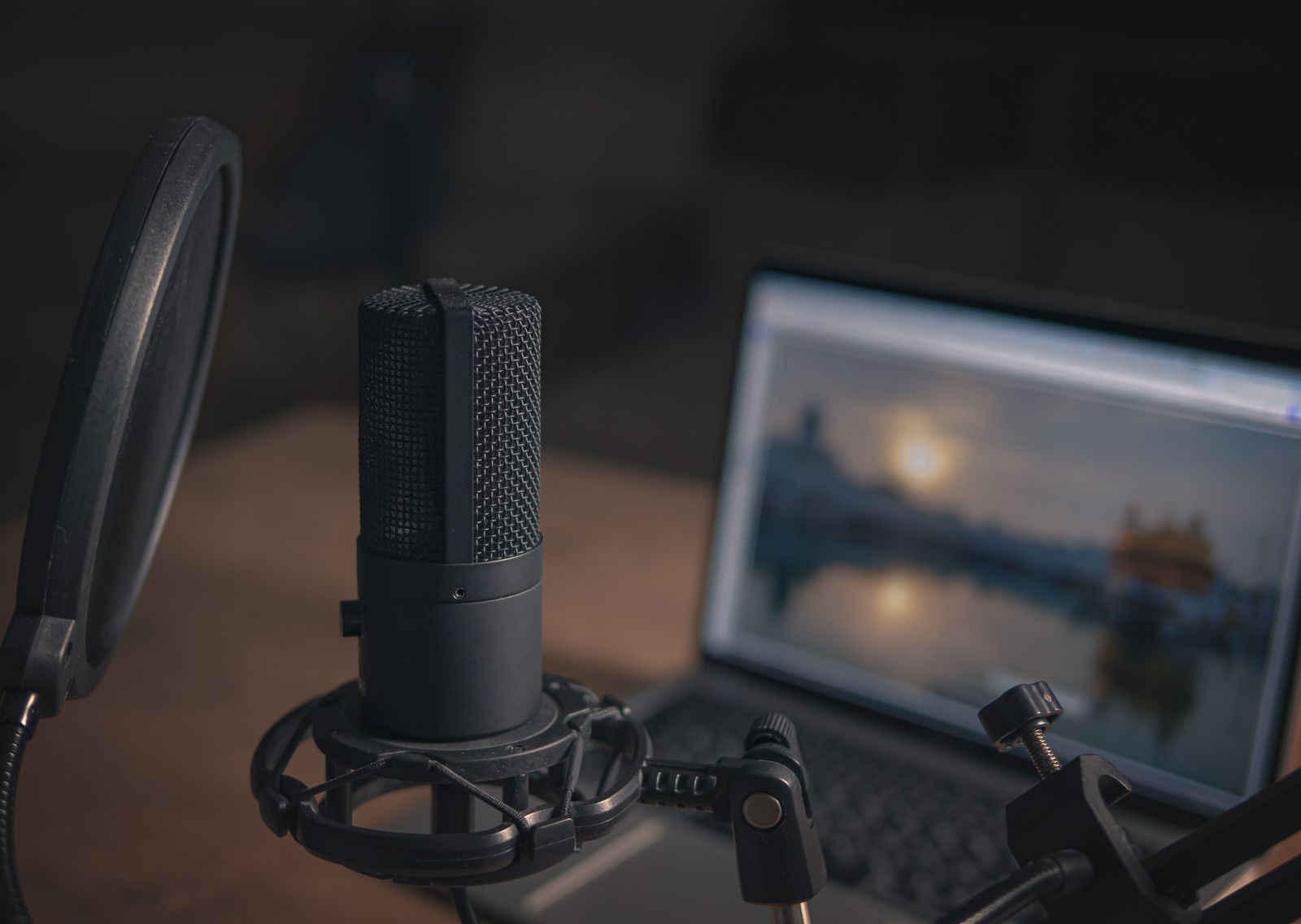 Microphone and pop filter beside a laptop