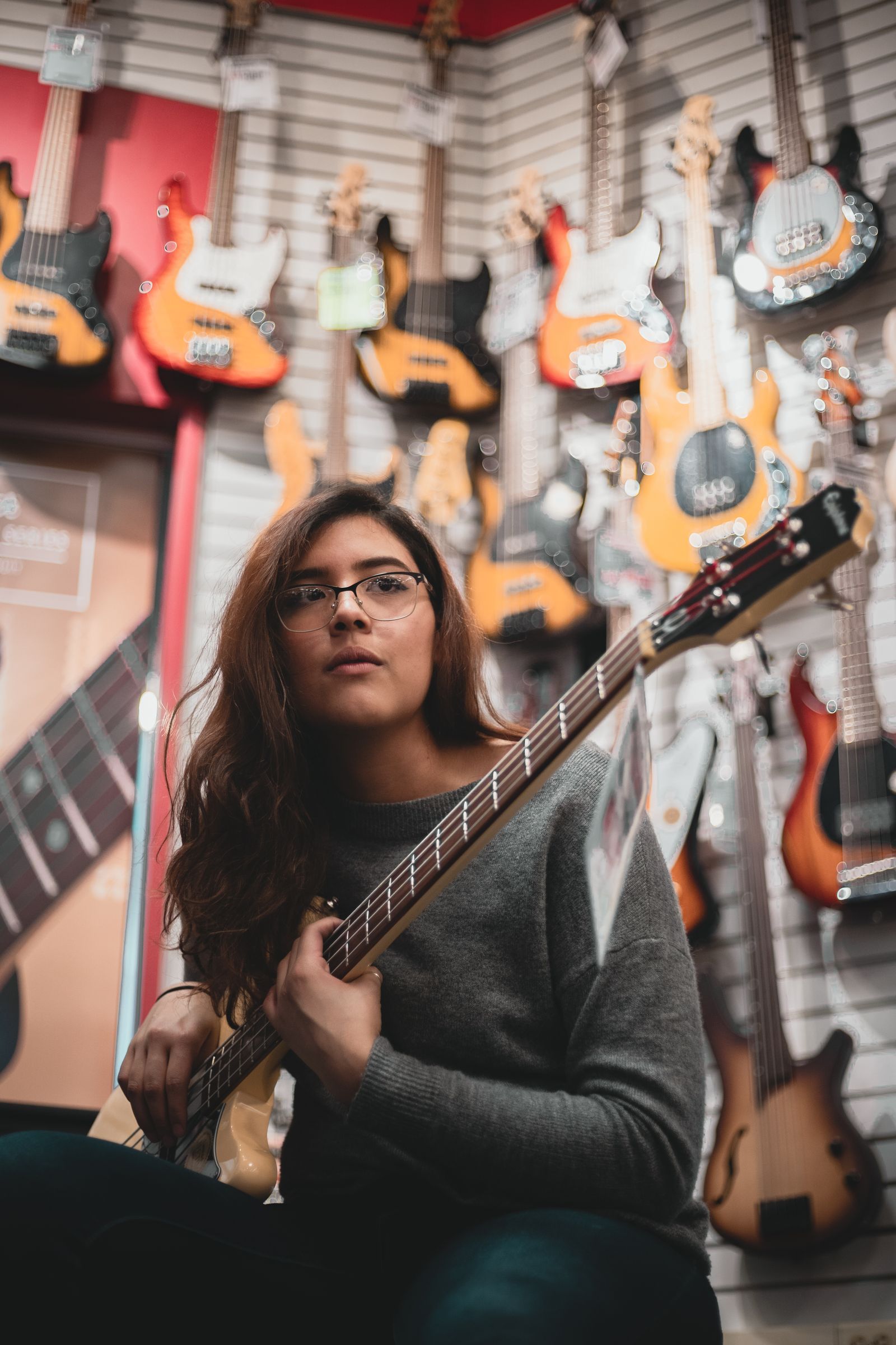 Musician holding a bass guitar in a music store