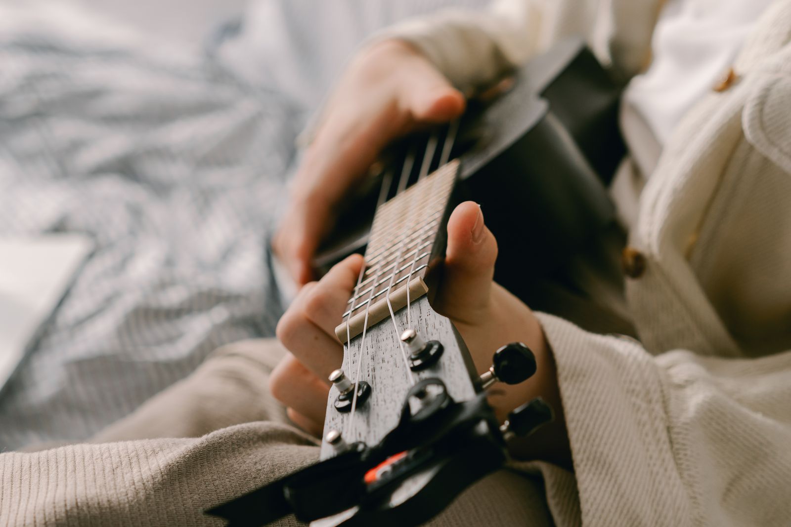 Hands playing a ukulele