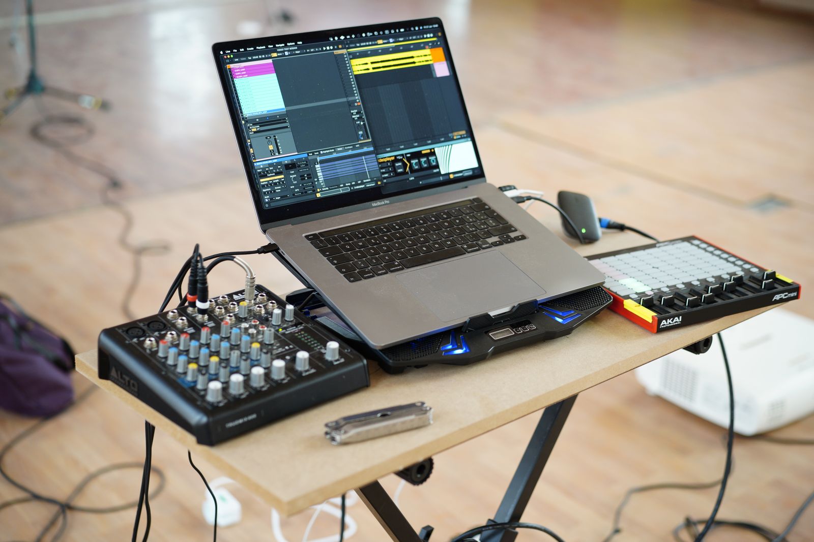 Laptop running a music session beside a mixer and controller