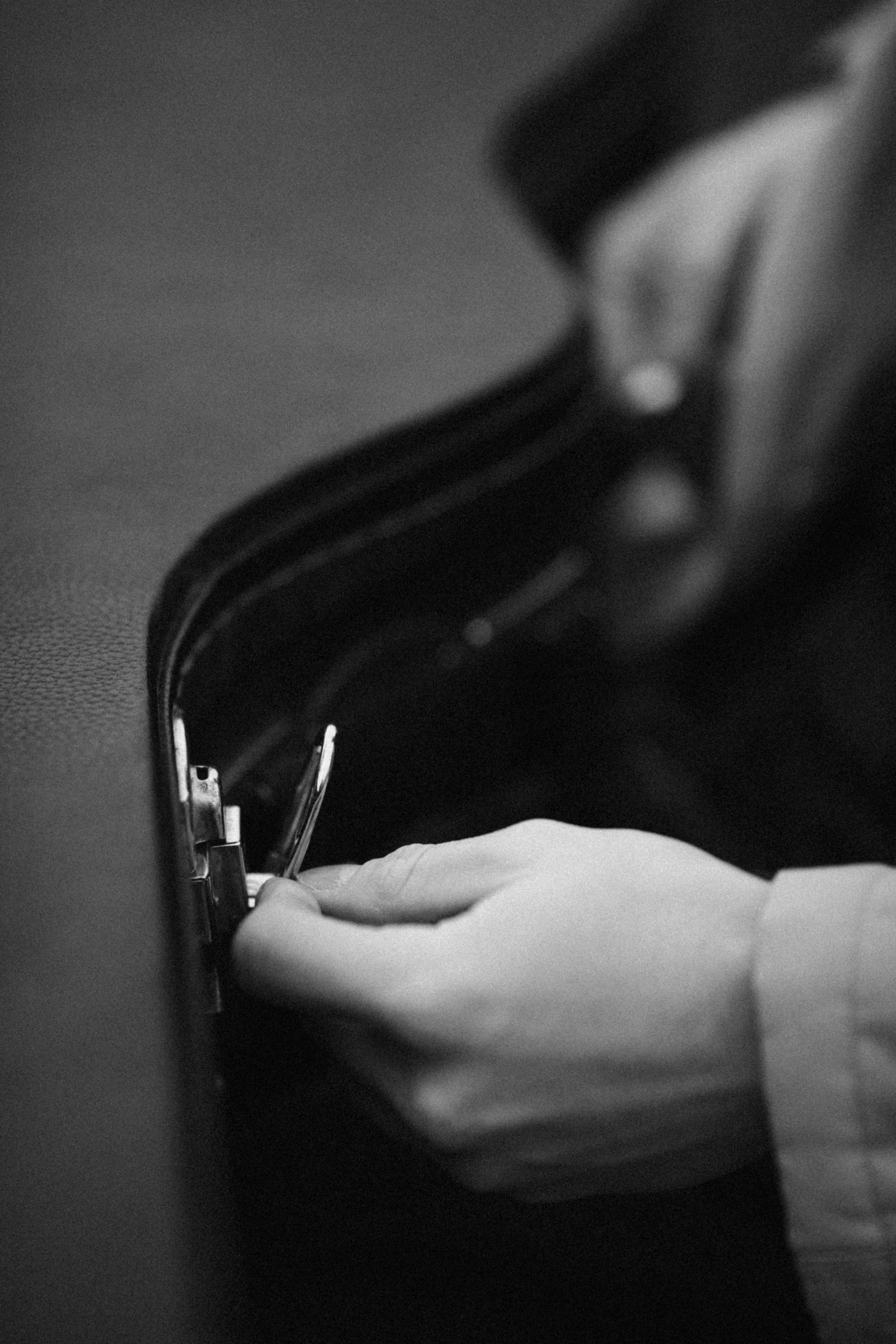 Hands opening the clasp of a guitar case